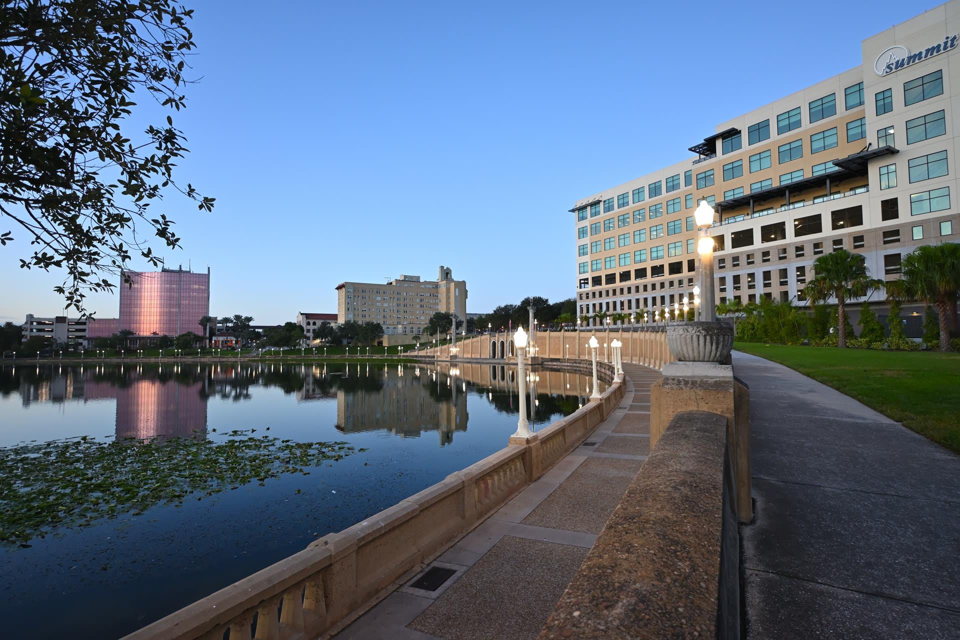 Lake Mirror Promenade bridge and downtown Lakeland skyline reflected in the water at dusk in Polk County, Florida