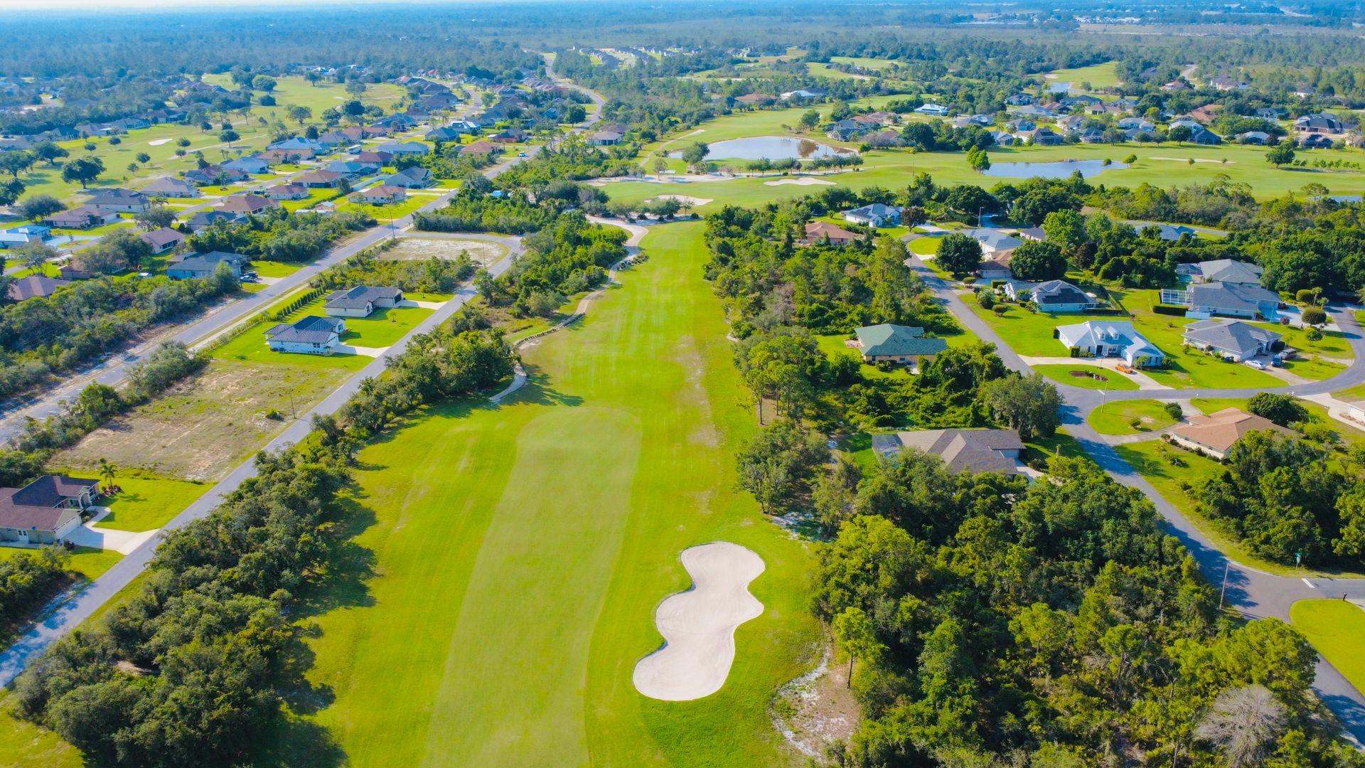 Aerial view of a suburban golf course community — the defining landscape of Sumter County, Florida's Villages country